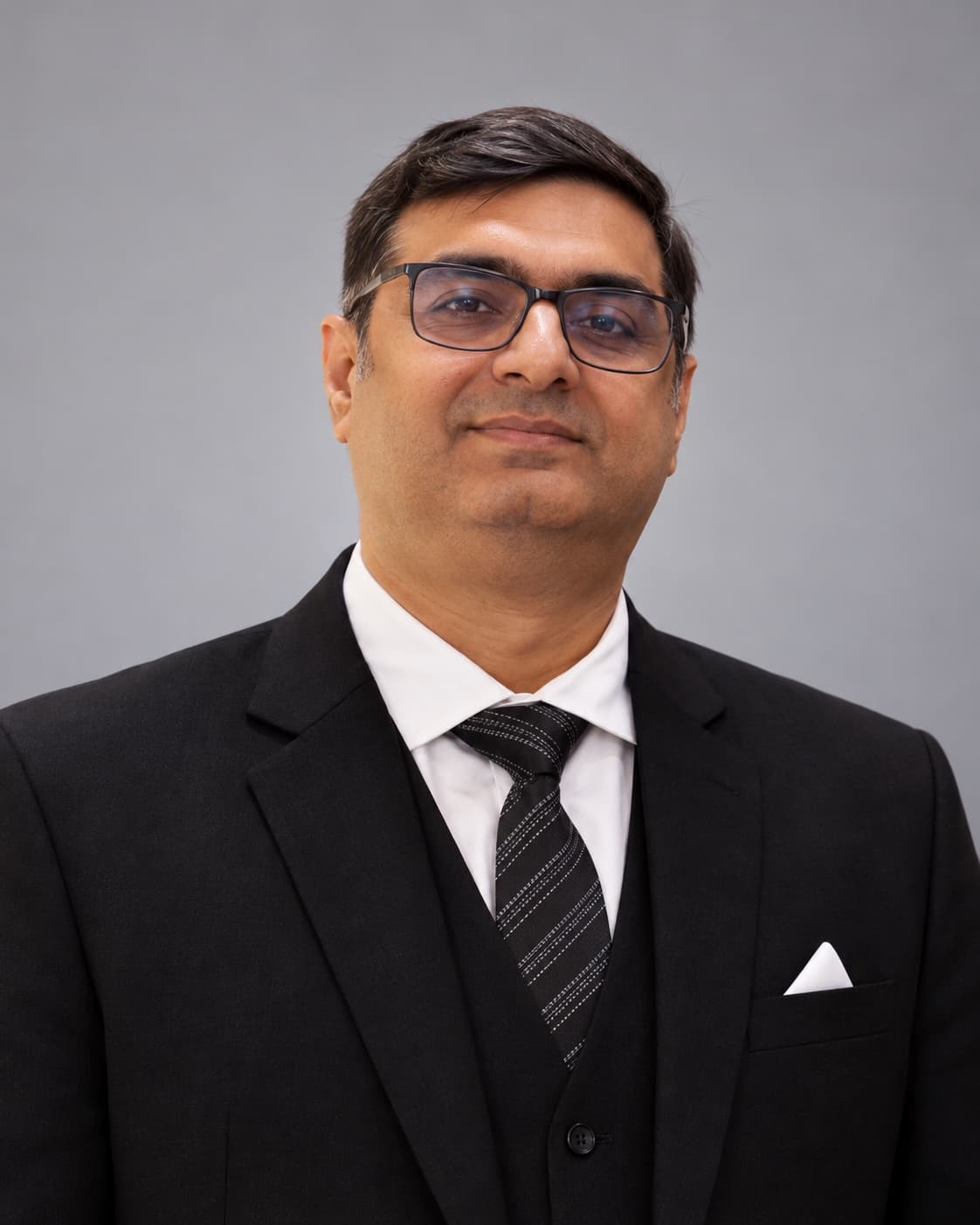 Professional portrait of Gagan Chugh in a black suit against a neutral studio background